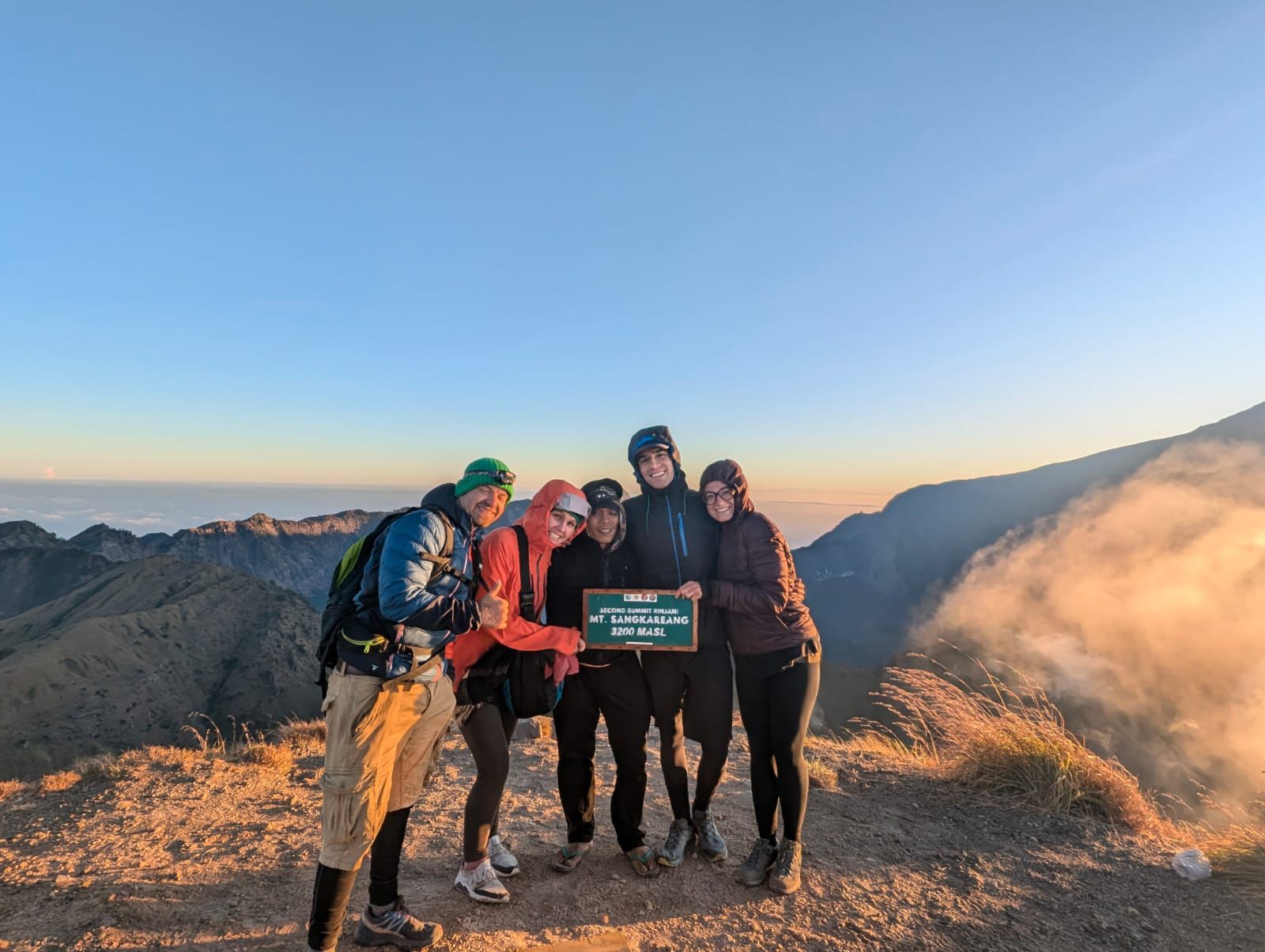 Group at the Mt Sangkareang second summit sign at sunrise