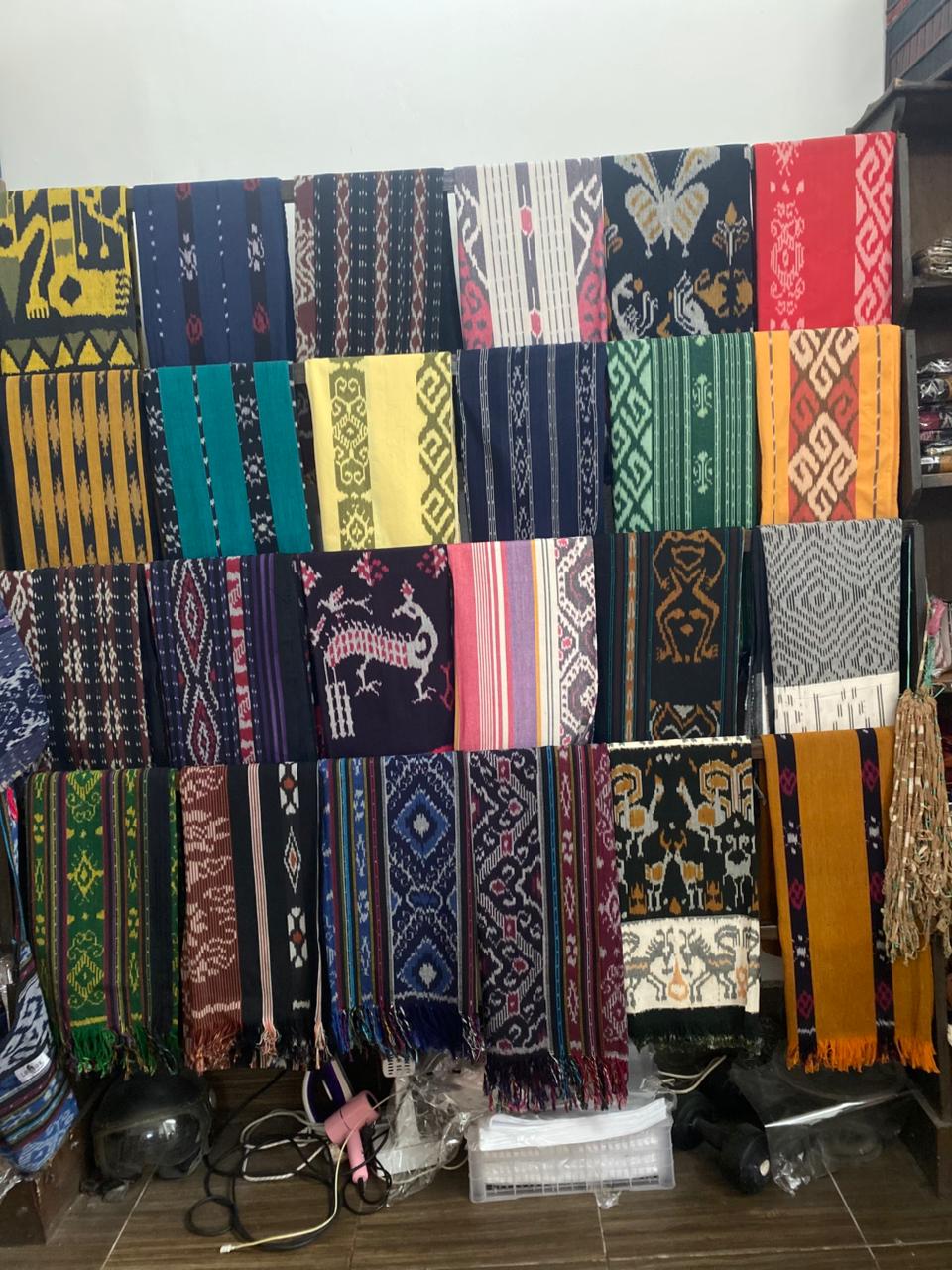 Traditional Sasak ikat and songket textiles hanging at a local weaver's home in Lombok